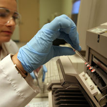 A food scientist inserting samples into an instrument