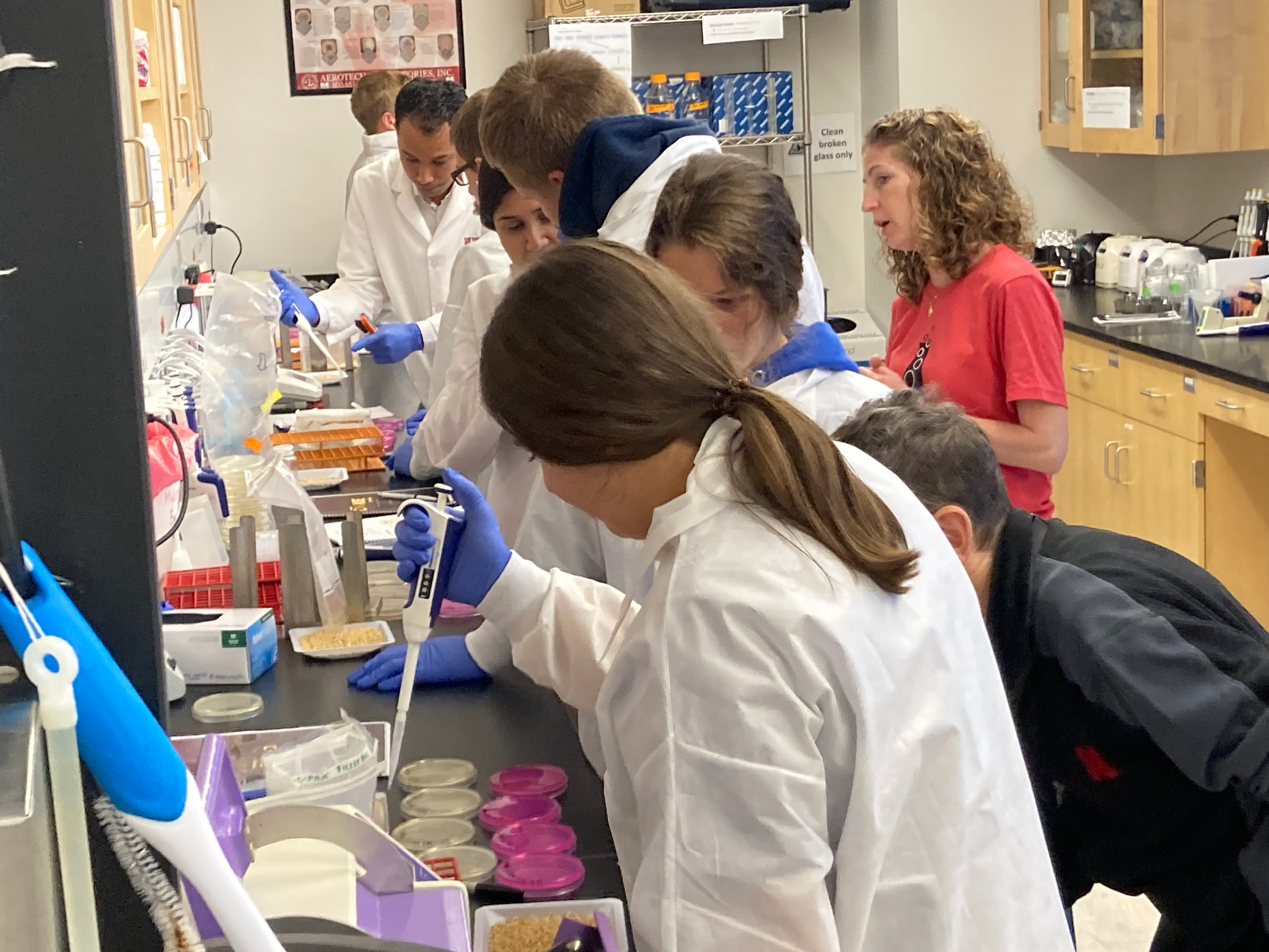 A group of scientists and children doing experiments together in a lab.