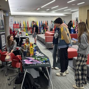 Students interact in a brightly lit room with research on display